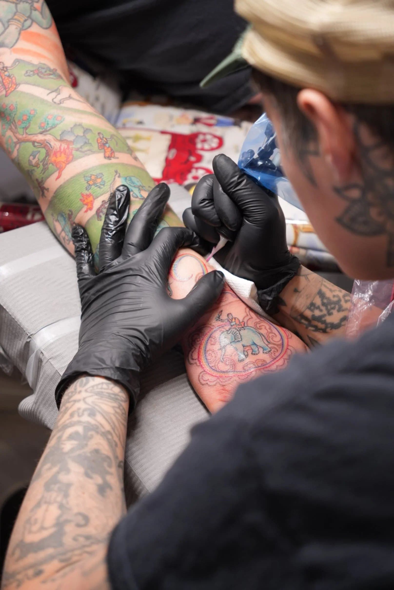 Halifax tattoo artist working on a client's hand in black nitrile gloves